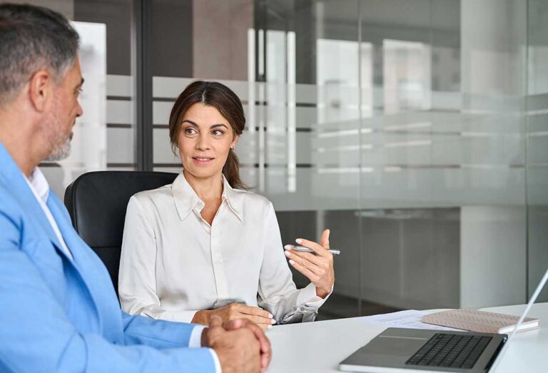 A person reviewing legal documents at a table with a pen and a binder nearby.